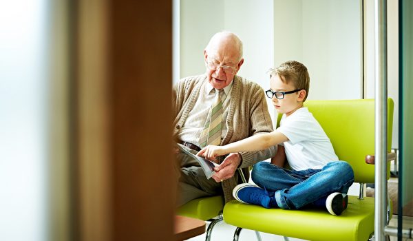 Little Boy With His Grandfather Sitting In Waiting Room