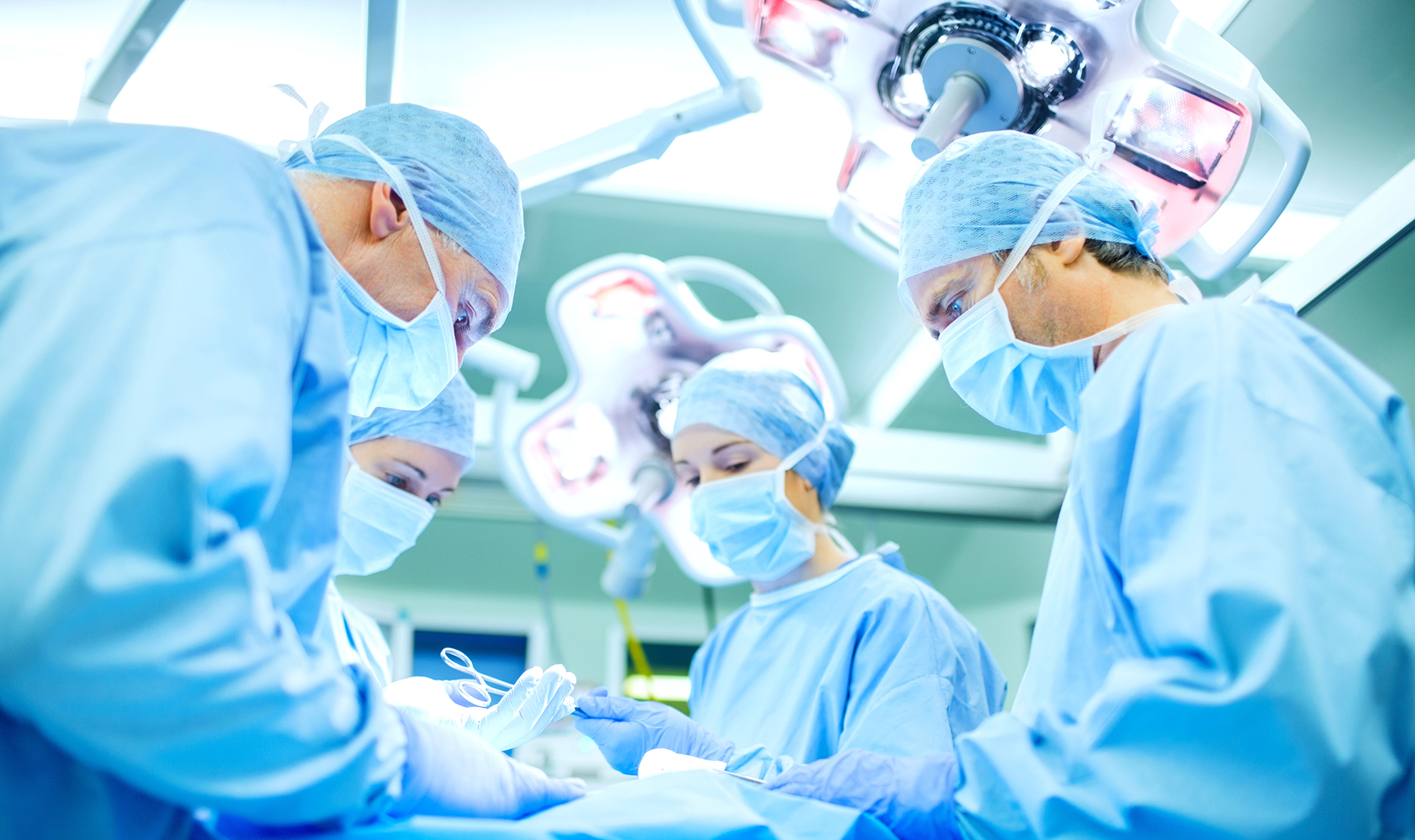 Surgeons Performing Surgery On Patient In Operating Room