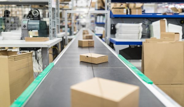 Cardboard Boxes On Conveyor Belt At Distribution Warehouse