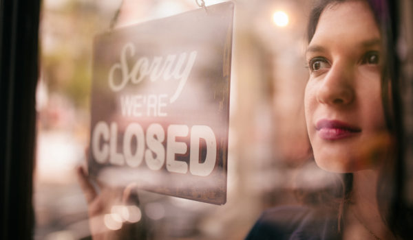 Business Woman Turning Closed Sign On Door Of Coffee Shop